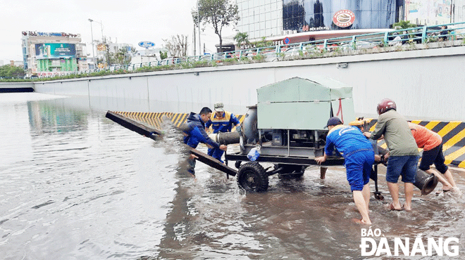 Lực lượng chức năng xử lý tình trạng ngập nước tại nút giao thông Nguyễn Tri Phương - Điện Biên Phủ do trận mưa lớn ngày  14-10 gây ra. Ảnh: GIA MINH