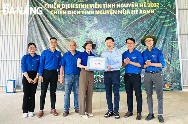 Nguyen Thanh Dat (second from left) and other volunteers presenting a gift to residents in difficult circumstances. Photo: THANH NGOC