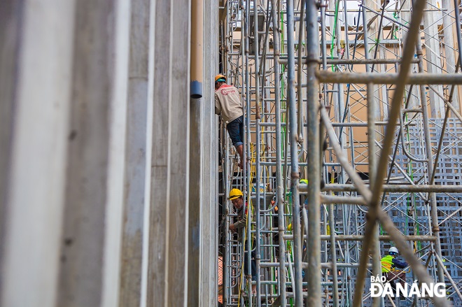 Construction workers are seen working at noon.