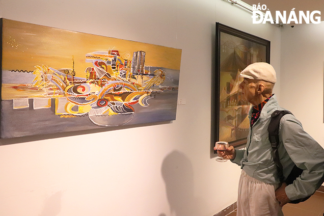 A foreign tourist admiring work of art displayed at the exhibition. Photo: X.D