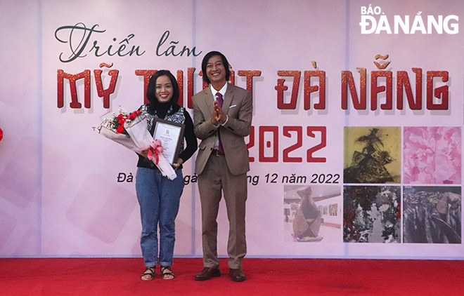 Chairman of the Da Nang Fine Arts Association Ho Dinh Nam Kha (first, right) presenting the first prize for the work ‘Childhood’ by painter Nguyen Thi Dao. Photo: X.D