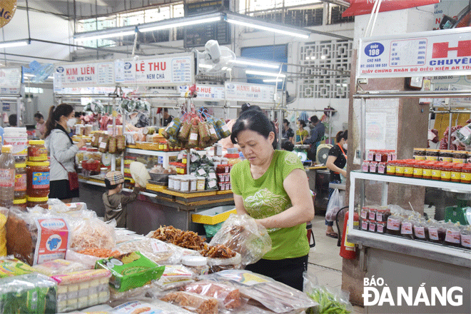 The city's industry and trade sector is proactively preparing for goods to serve the year-end shopping. IN THE PHOTO: A small trader at the Han Market is displaying Tet goods.