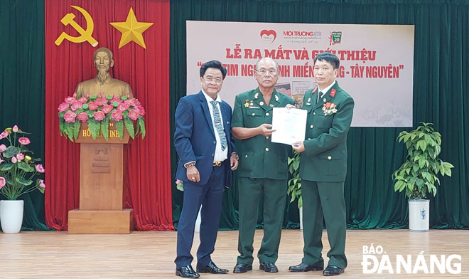 Colonel and writer Dang Vuong Hung (right) handing over the decision to establish the ‘Hearts of Soldiers in Central Viet Nam and Central Highlands Regions’ Club to Veteran Dang Van Huong (middle). Photo: DUYEN ANH