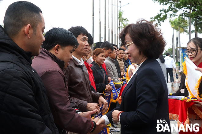 Vice Chairwoman of the municipal People's Committee Ngo Thi Kim Yen presents souvenir flags to representatives from the groups of participating runners