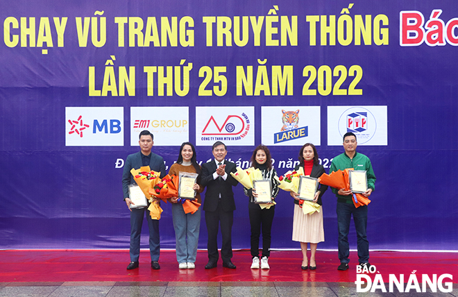 DA NANG Newspaper Editor-in-chief cum Head of the competition’s organisers Nguyen Duc Nam (3rd, left) presenting flowers and medals to sponsors