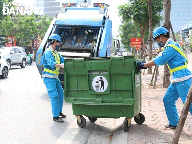 Công nhân Công ty TNHH MTV Môi trường Đô thị Hà Nội (Urenco)- Chi nhánh miền Trung, thu gom rác thải từ các khu dân cư.Ảnh: CHIẾN THẮNG