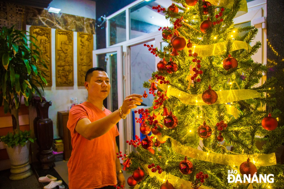 Pham Minh Nhat, 41, residing on Tran Cao Van Street, is decorating lights and items for his Christmas tree.