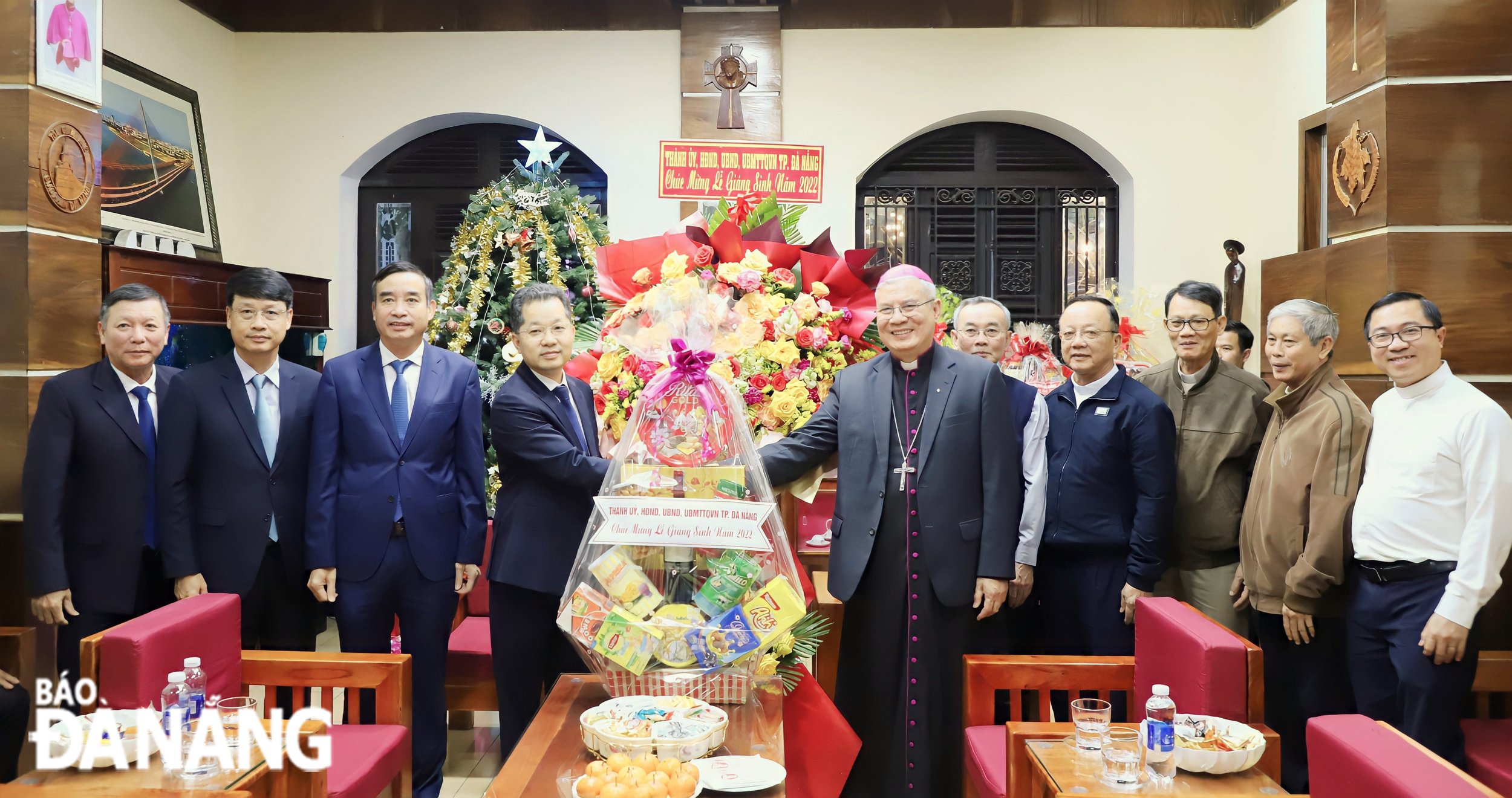 Bí thư Thành ủy Nguyễn Văn Quảng (thứ 4, bên trái sang) tặng hoa chúc mừng Giám mục Đặng Đức Ngân. Ảnh: NGỌC PHÚ