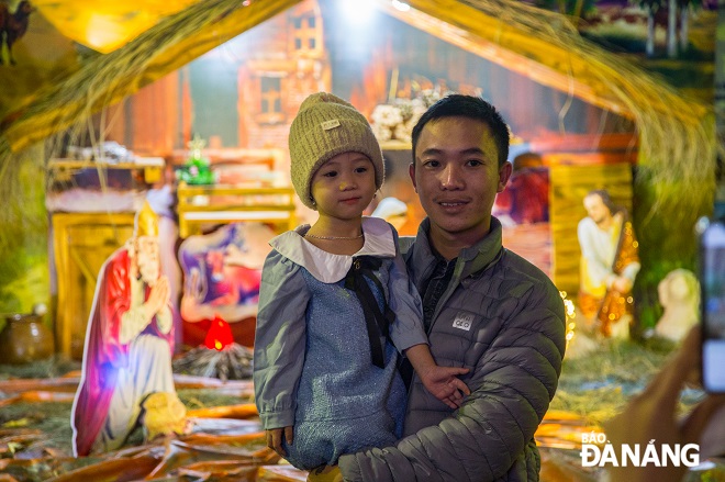 A father and her daughter posing for a souvenir photo on Christmas season