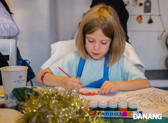 A Russian girl is passionately colouring her sticker