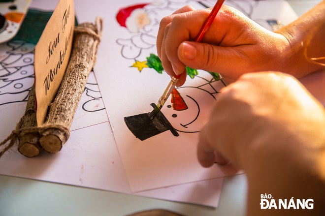 During the event, child participants had the opportunity to freely color in wooden stickers, design Christmas wooden cards and Christmas tree decorations, take part in many games to learn about the Son Tra Peninsula, and experience a lively Christmas music night.