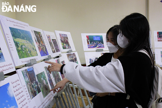 Young people admire the pictures of Co Tu brocade weaving taken by the community.