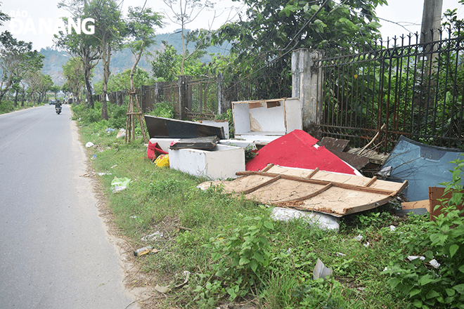Bàn ghế, tủ gỗ, mặt kính và túi ni lông bị vứt trên đường Lê Hiến Mai (phường Hoà Minh, quận Liên Chiểu), ngay cổng chào dẫn vào khu đô thị Phước Lý. 