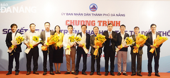 Chairman of the Da Nang People's Committee Le Trung Chinh, (4th, right) presented flowers and congratulated press agencies participating in the media cooperation programme. Photo: TRONG HUNG