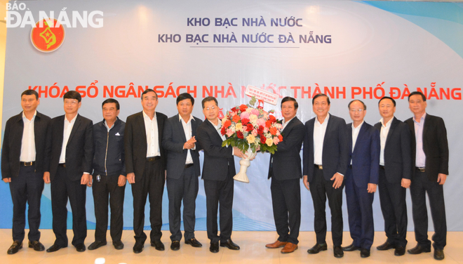 Lãnh đạo thành phố tặng hoa chúc mừng khóa sổ ngân sách năm 2022 của thành phố vượt chỉ tiêu được giao. Ảnh: M.Q