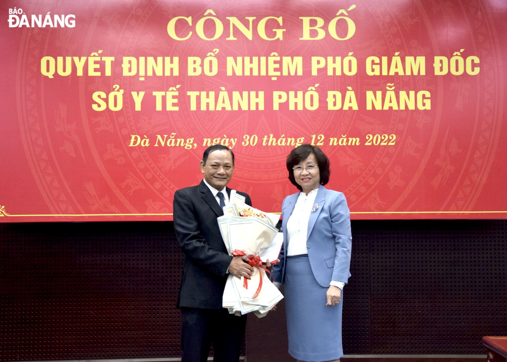 Phó Chủ tịch UBND thành phố Ngô Thị Kim Yến (bên phải) trao quyết định, tặng hoa chúc mừng ông Võ Thanh Tùng. Ảnh: T. HUY