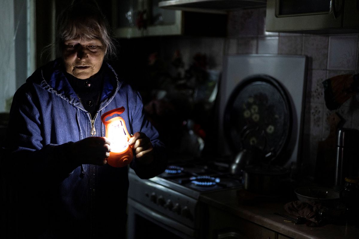 Bà Olga Kobzar bật bếp ga để sưởi ấm trong căn hộ ở khu phố Saltivka của Kharkiv, Ukraine. Ảnh: Reuters