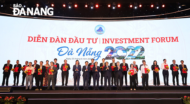 Prime Minister Pham Minh Chinh and Da Nang leaders along with honourees who were chosen for their large investment projects in the city, the completion of their projects ahead of schedule, and their dedication and commitment to the city’s investment promotion activities. Photo: V.HOANG