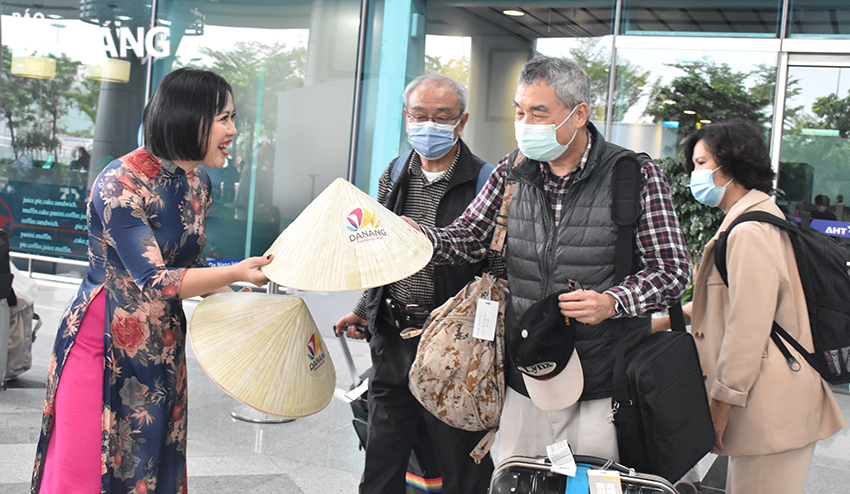 International tourists are excited to receive Vietnamese conical hats as gifts. Photo: THU HA