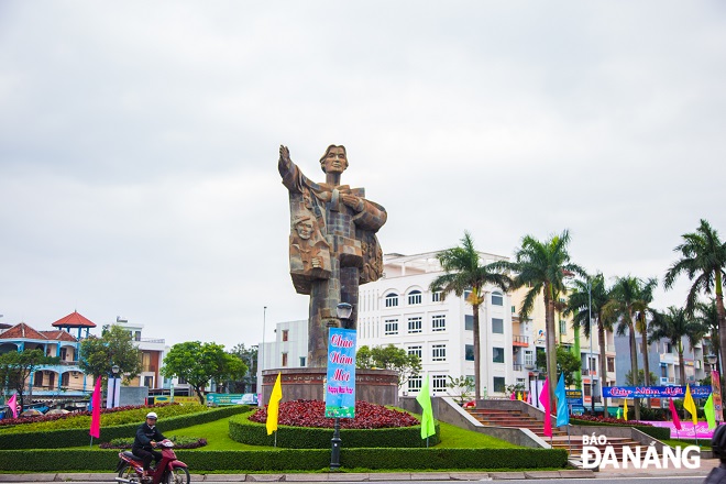 The statue of Mother Nhu in Thanh Khe District is decorated with colorful flags and flowers.