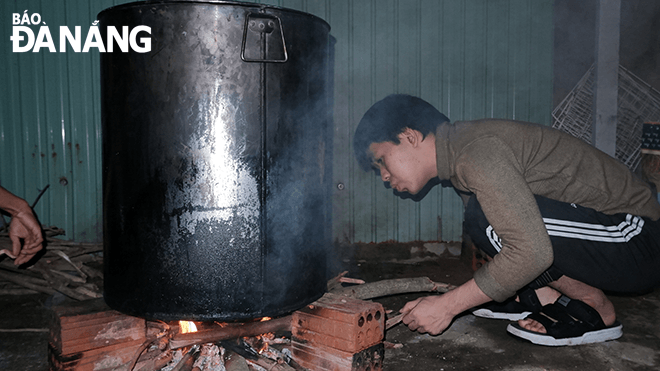 Le Xuan Trung, a member of the Da Nang Hope Volunteer Club, is building a fire to cook porridge.