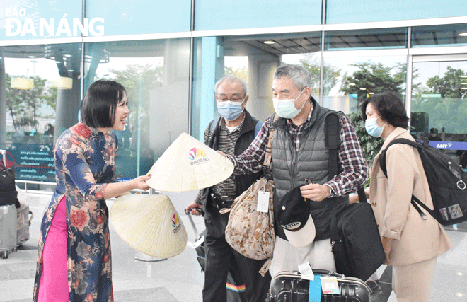 International tourists are excited to receive Vietnamese conical hats as gifts. Photo: THU HA