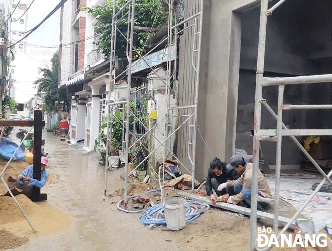 Các công nhân xây dựng đang cố gắng hoàn thiện một ngôi nhà trước Tết. Ảnh: GIA MINH