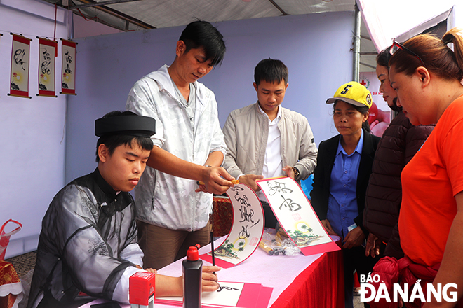 Visitors to the fair had a chance to participate in fun folk games in Tet. In the photo: Giving free calligraphy letters to visitors. Photo: X.D