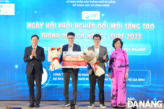 Thứ trưởng Bộ Khoa học và Công nghệ Trần Văn Tùng (bên trái) và Phó Chủ tịch UBND thành phố Ngô Thị Kim Yến (bên phải) trao giải Nhất cho dự án “Mô hình tủ nuôi đông trùng hạ thảo quy mô hộ gia đình” của Công ty TNHH Công nghệ sinh học Vinseed. Ảnh: L.V
