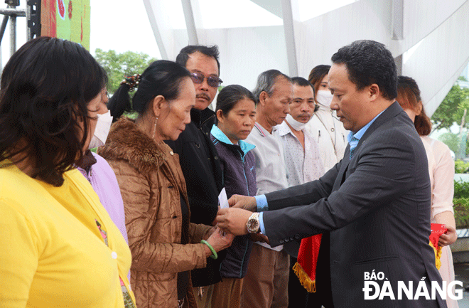 Chairman of Hai Chau District Peoples Committee Le Tu Gia Thanh (right) presenting Tet cash gifts to disadvantaged people as part of the city’s program entitled 