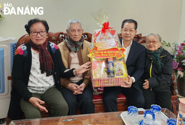 Mr Quang (second, right) presenting a gift and extending his Tet greetings to the family of wounded soldier Tran Viet Kiem. Photo: PHAN CHUNG