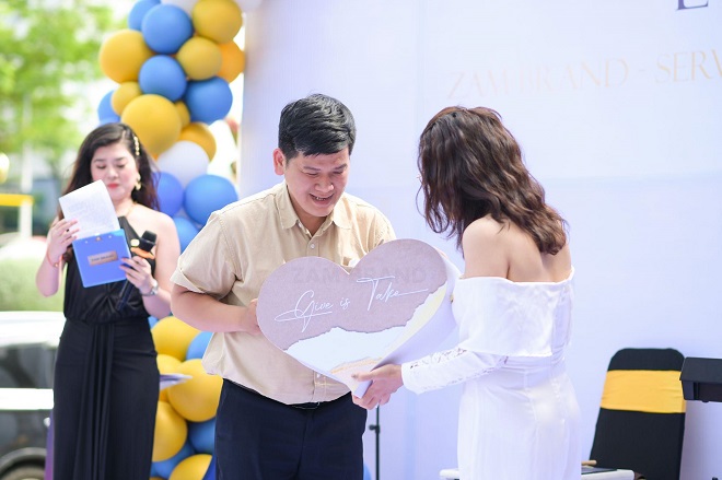 Mrs Coo Zĩm - Nhà sáng lập thương hiệu ZAM brand trao tặng tiền chúc mừng từ khách mời cho quán Yên Vui.