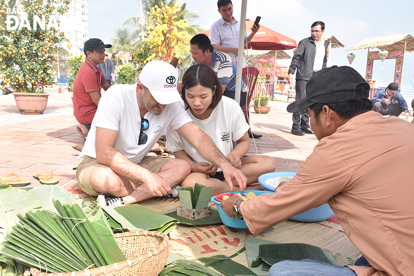 Mr. Martin Czabel from Australia experiences the wrapping of 'banh chung' and 'banh tet'. Photo:THU HA