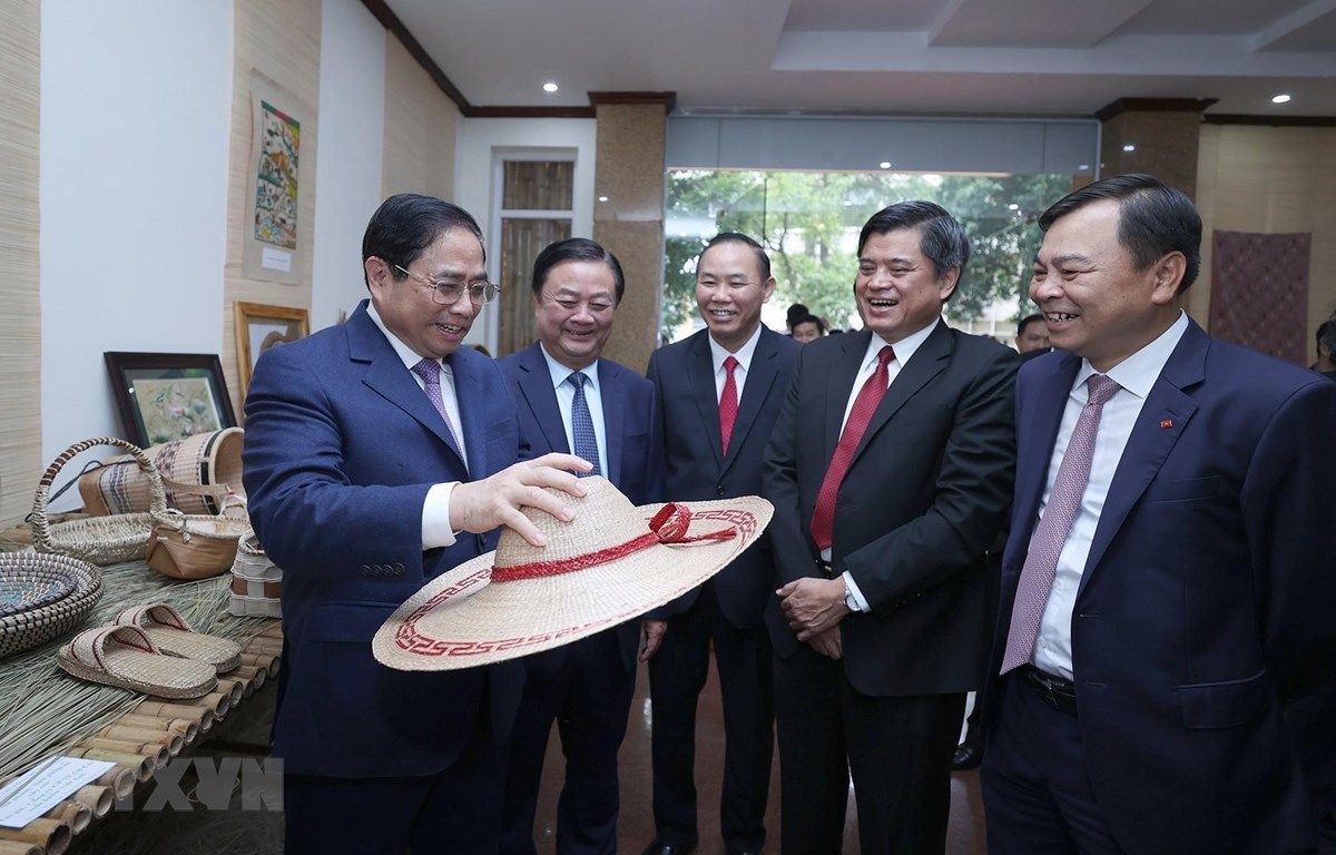 Thủ tướng Phạm Minh Chính xem trưng bày các sản phẩm nông nghiệp, thủ công mỹ nghệ. (Ảnh: Dương Giang/TTXVN)