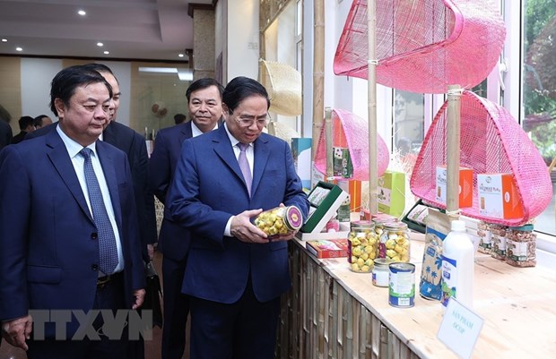 Thủ tướng Phạm Minh Chính xem trưng bày sản phẩm nông nghiệp, thủ công mỹ nghệ. (Ảnh: Dương Giang/TTXVN)