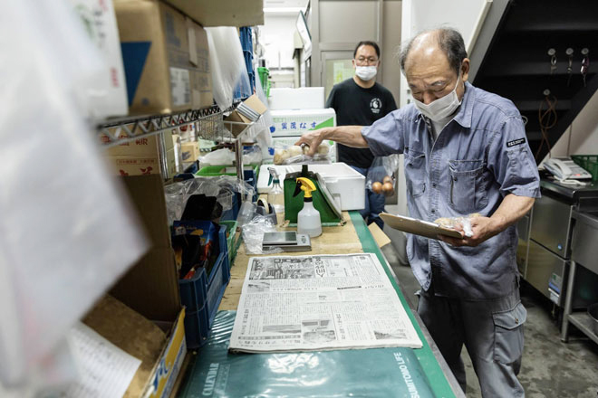 Ông Yoshihito Oonami làm việc tại một cửa hàng sản phẩm tươi sống ở Tokyo, Nhật Bản. Ảnh: NYT 