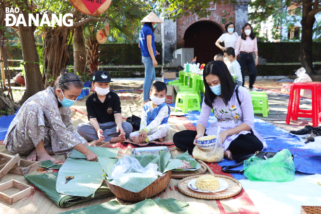 Người dân và trẻ em trải nghiệm làm bánh chưng xanh tại chương trình “Phiên chợ ngày Tết” do Bảo tàng Đà Nẵng tổ chức. Ảnh: X.D