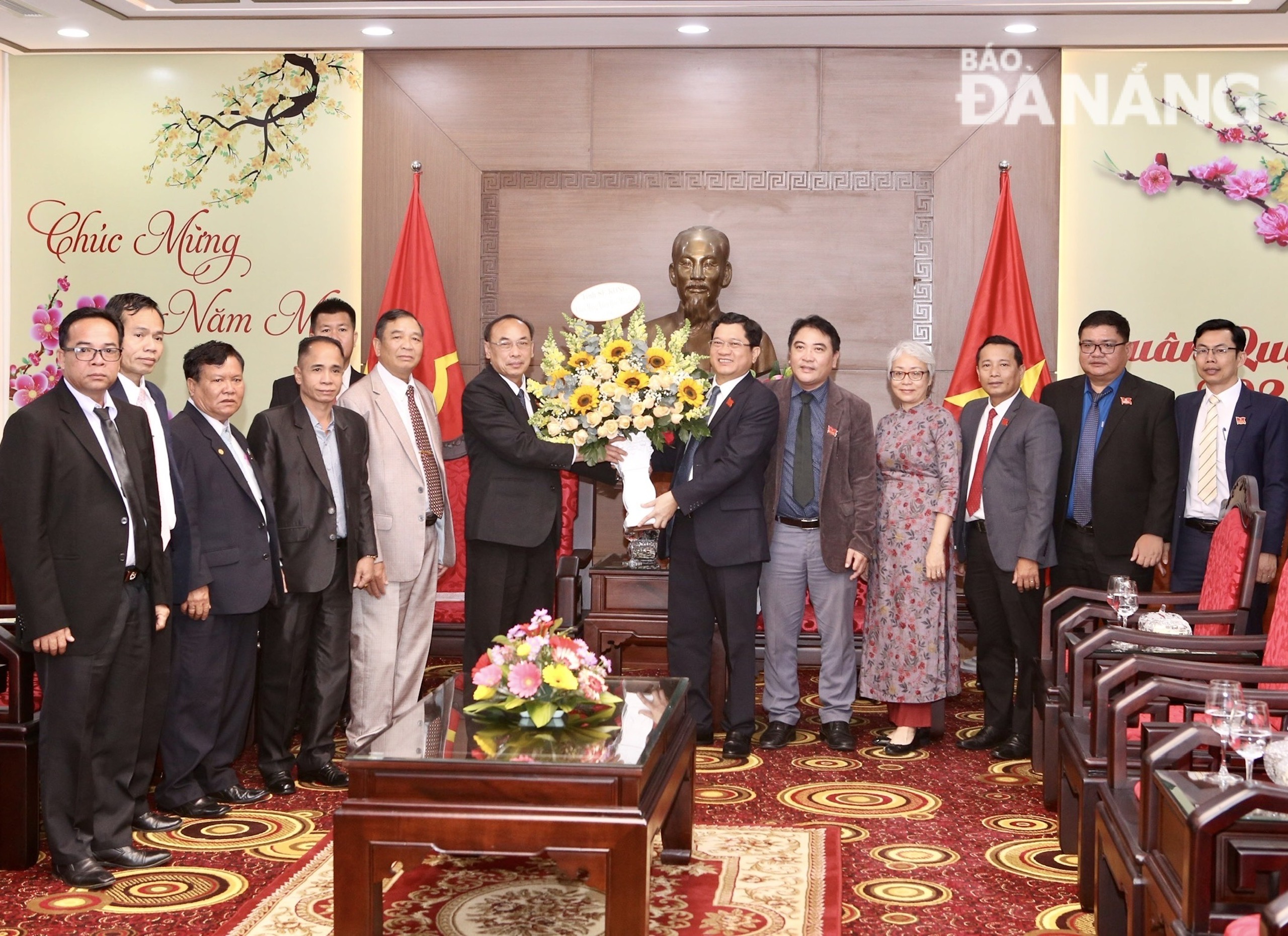 Deputy Secretary of the provincial Party Committee cum Chairman of the provincial People's Council DongPhet Phanhon (sixth, left) presents flowers to congratulate Da Nang on the occasion of the Lunar New Year 2023. Photo: T.P