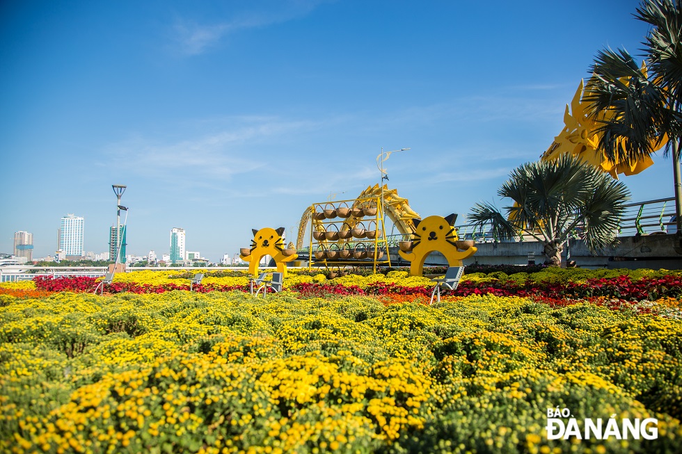 At the east bank of the Dragon Bridge in Son Tra District, the construction unit is seen installing stylized cat mascot models, and decorating flowers and miniatures.