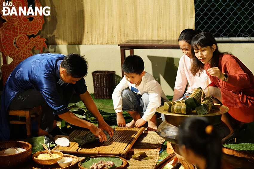 Visitors are seen experiencing the making of 'banh chung' and 'banh tet'