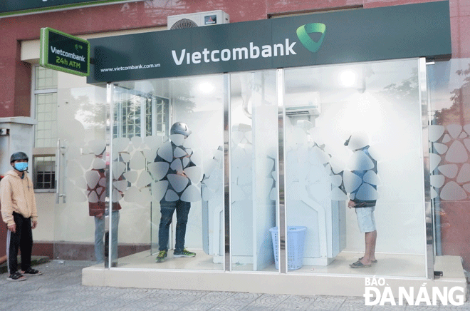 Tình trạng chờ đợi lâu tại các máy ATM để rút tiền dịp cận Tết không nhiều.  Trong ảnh: Người dân rút tiền tại ATM Vietcombank Hòa Khánh (quận Liên Chiểu). Ảnh: M.Q	