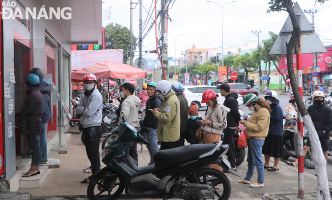 Người dân xếp hàng chờ rút tiền cây ATM của Ngân hàng TMCP Kỹ thương Việt Nam (Techcombank) tại ngã tư Ngô Văn Sở - Tôn Đức Thắng (quận Liên Chiểu) sáng 18-1 (27 tháng Chạp). Ảnh: M.Q