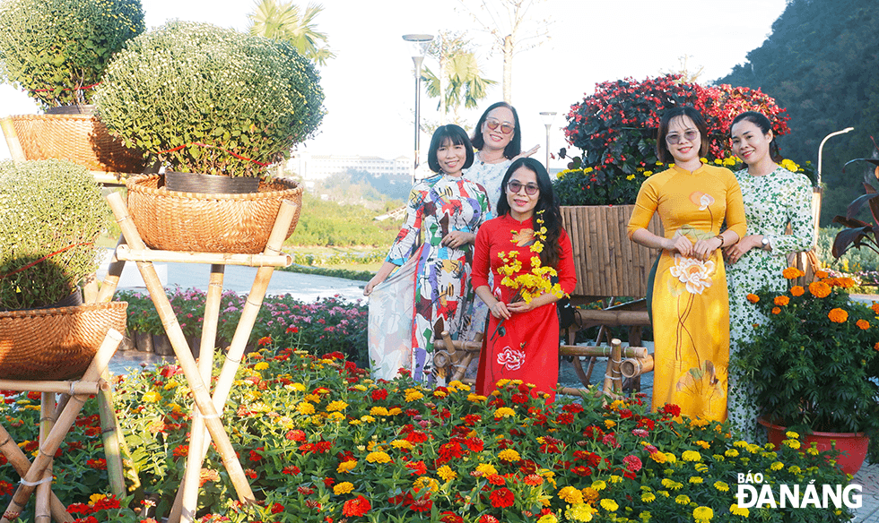 Huynh Thi Hoa, 38, (3rd, right) and her friends wore 'ao dai' to save their memorable moments on the occasion of Tet. She said although its construction process was short, the flower garden has brought a very impressive beauty with the highlight of the mountains and flowers are arranged in harmony, very satisfying my expectations. Photo: THU DUYEN