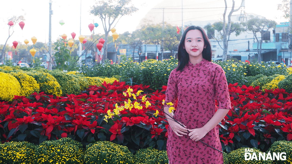 Many young people wear traditional 'Ao Dai' to keep beautiful moments with the flower garden. Photo: THU DUYEN