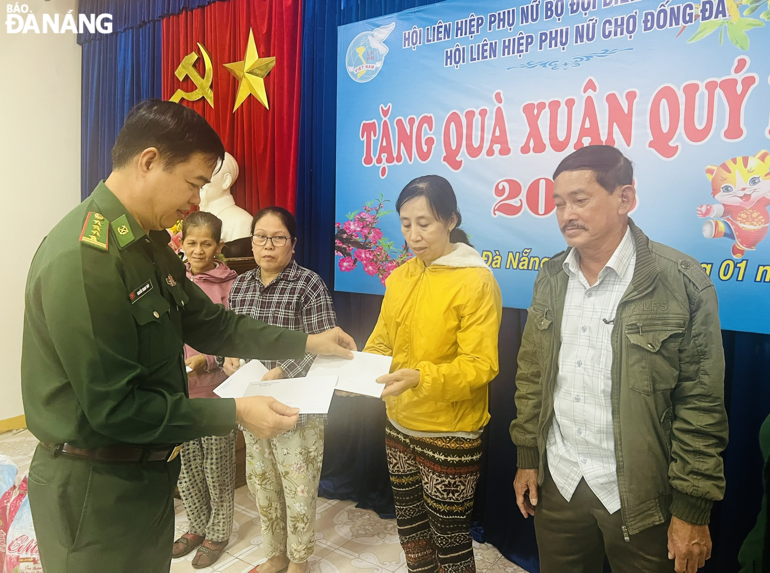 A local Border Guard officer (left) gives Tet gifts to disadvantaged households in Thuan Phuoc Ward.