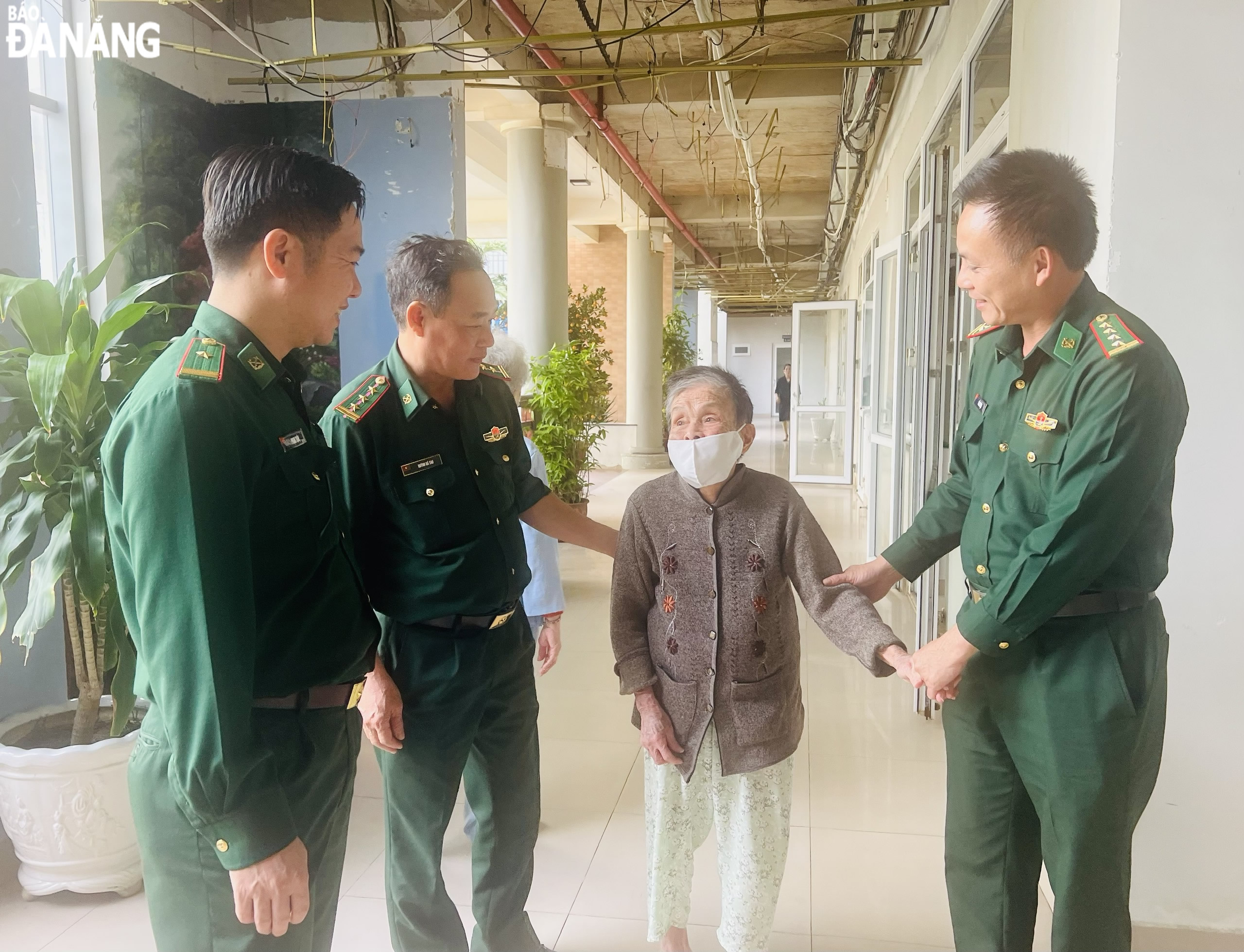 A local Border Guard officer (right) gives gifts and extends Tet wishes for those who stay at the city’s Centre for Caring People with Meritorious Services to the city's Revolution.