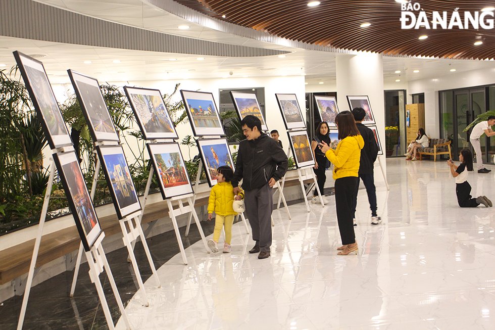 Người dân xem triển lãm ảnh tại Công viên APEC trong khi chờ đợi đến giờ bắn pháo hoa. Ảnh: QUỐC CƯỜNG