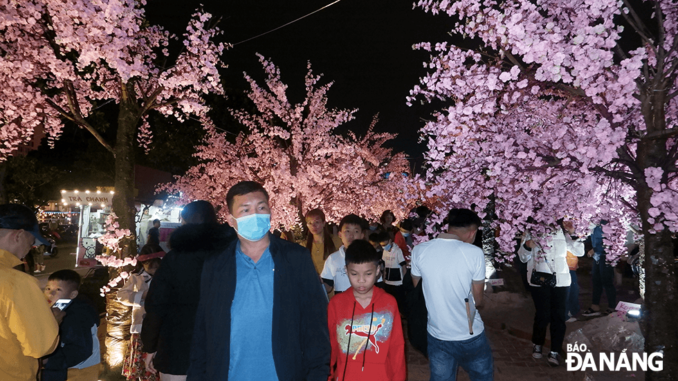 Đông đảo người dân đến tham quan đường hoa ven bờ tây sông Hàn. Ảnh: THU DUYÊN