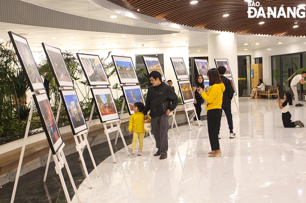 People enjoy a photo exhibition at the APEC Scupture Garden while waiting for fireworks shows. Photo: QUOC CUONG