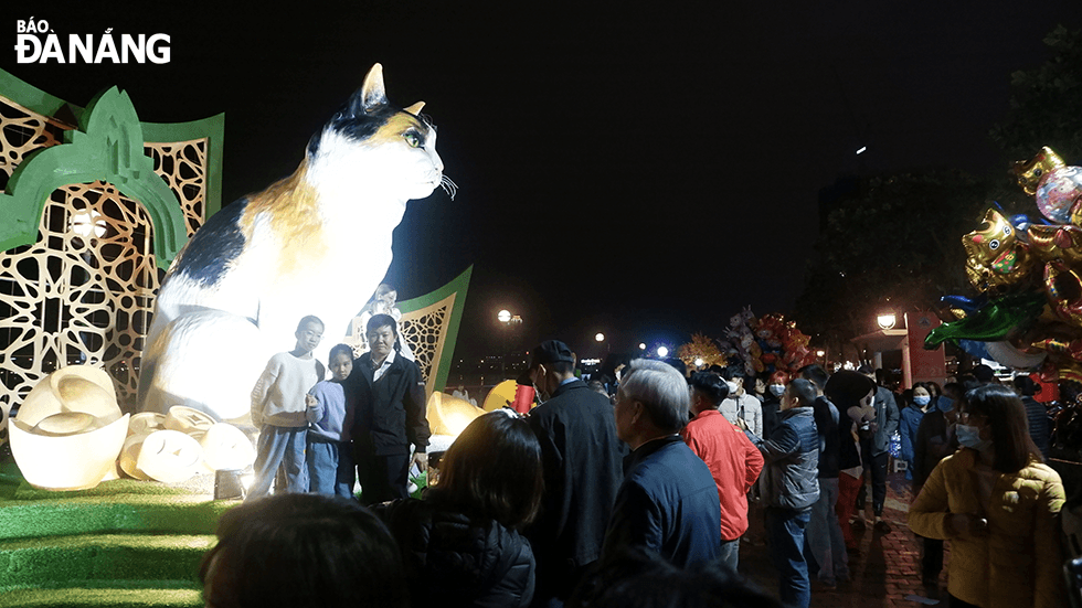 Visitors take photos with the cat mascot placed on the western bank of the Han River